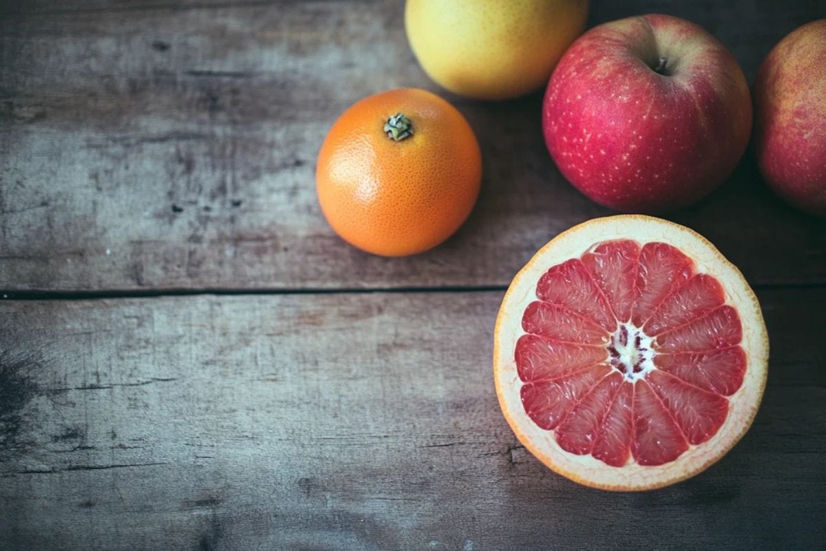 photo of grapefruit and apples on a wooden table