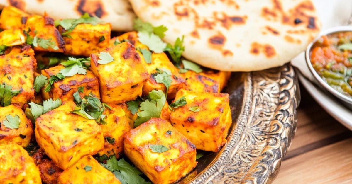 Tandoori Pumpkin Paneer served with naan and chutneys.