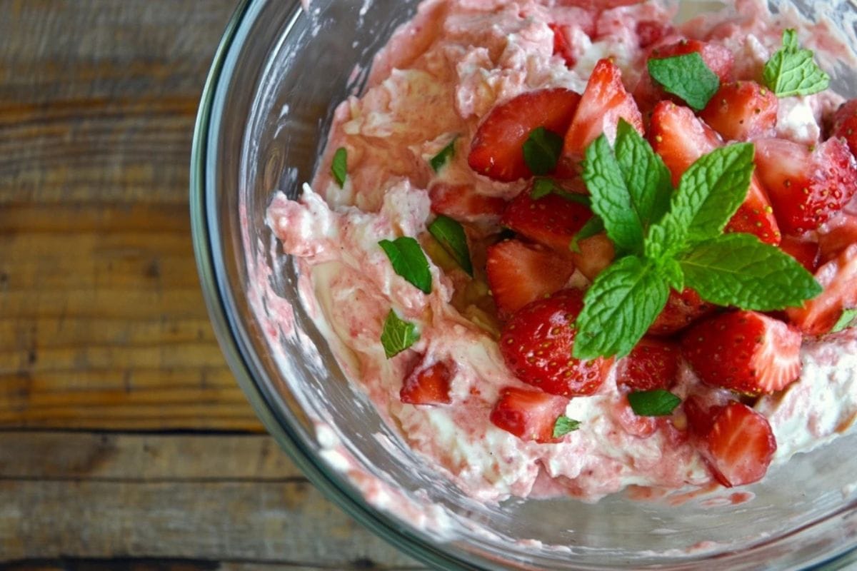 Bowl of strawberry cream cheese garnished with fresh strawberries.